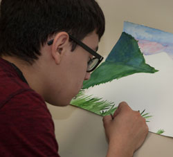 An Advertising Design and Commercial Art student creates a watercolor painting.