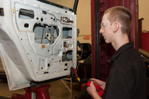 student repairing a car door