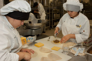 Two Culinary students prepare food in the kitchen.
