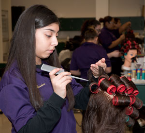 A Cosmetology student practices setting hair.