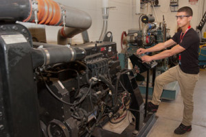 A student operates a large diesel engine in the learning lab.