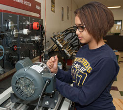 A student works with a piece of machinery in the engineering lab.