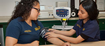 One student checks another's blood pressure.