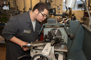 A student machines a part on a lathe as part of his Machine Shop Technology curriculum.