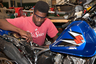 A student repairs a Suzuki motorcycle.