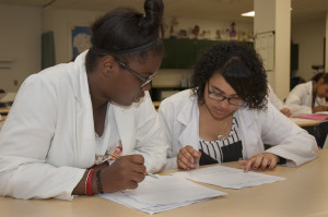 Two students review paperwork in Health–Medical Professions class.