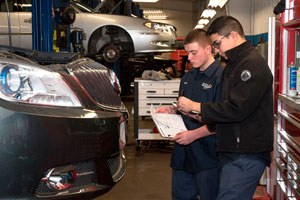 Two Auto Tech students prepare a new car for purchase from a dealer.