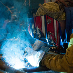 Intense light and smoke are produced by a student in welding class.