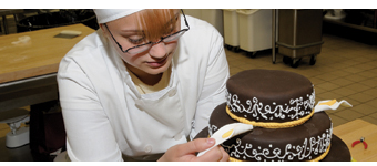 An RMCTC student decorates a fancy cake.