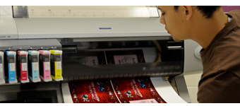 A student checks the output of a digital printer.