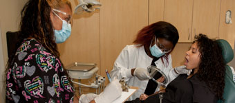 Dental Occupations students practice their skills on a fellow student who plays the role of patient.