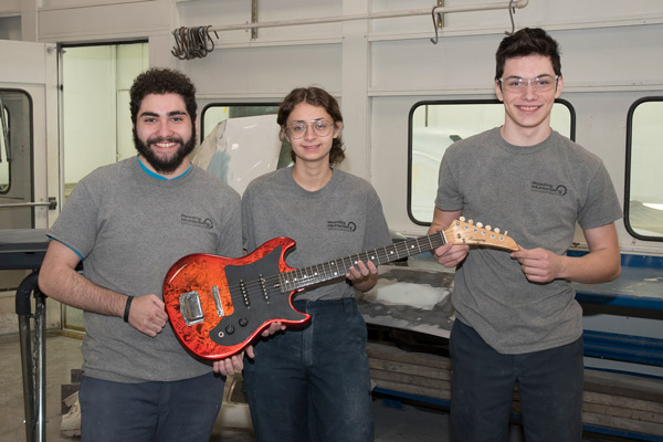 Three students who refurbished an old guitar
