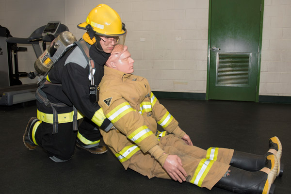 A PSS student simulates dragging an injured comrade from danger.