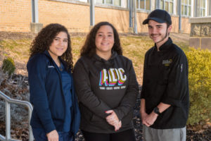 Three RMCTC students pose for a photo in front of the school.