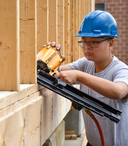 An RMCTC Carpentry student uses a nail gun.