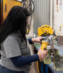 A student uses a grinder in the Auto Body Repair program.