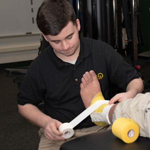 A Sports Medicine student practices wrapping an ankle injury.