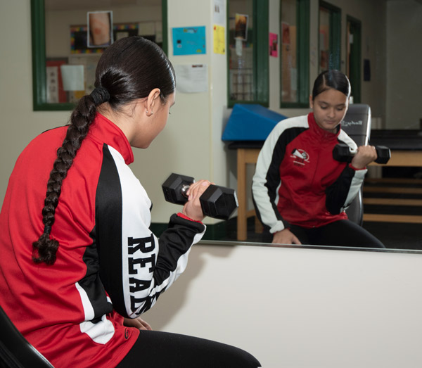 A Sports Medicine student demonstrates a bicep exercise.