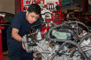 A student in the Automotive Technology program works on an engine.