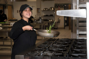 A student in the Culinary Arts program prepares some green beans.
